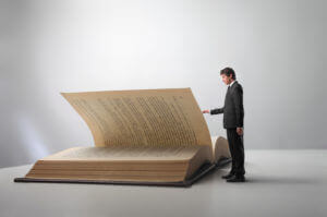 A Man Reading A Giant Book, Representing The Alcoholics Anonymous Big Book