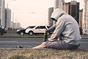 Men sitting on the roadside drinking